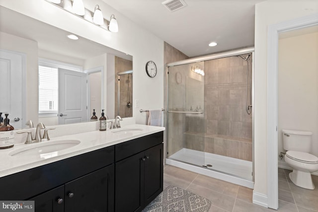 full bathroom featuring tile patterned floors, a stall shower, toilet, double vanity, and recessed lighting