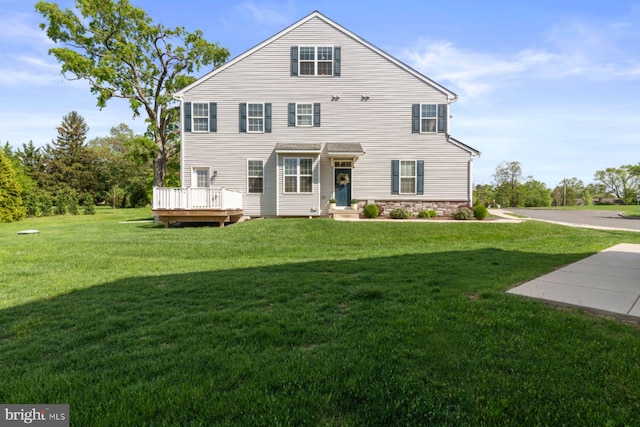 back of property with a lawn and a wooden deck