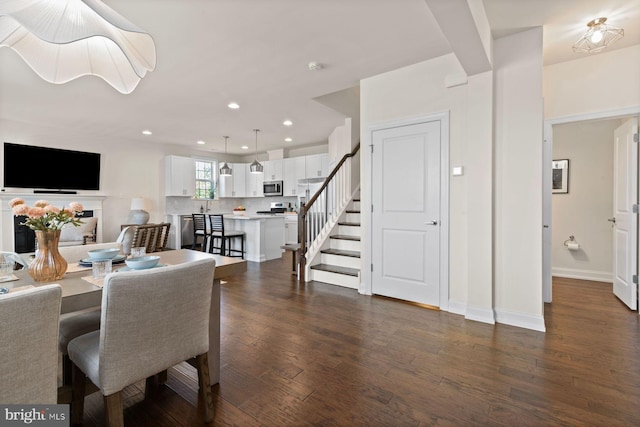 dining room featuring dark wood finished floors, baseboards, and recessed lighting