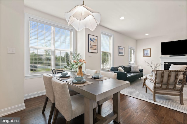 dining area featuring dark wood finished floors, baseboards, recessed lighting, and a fireplace