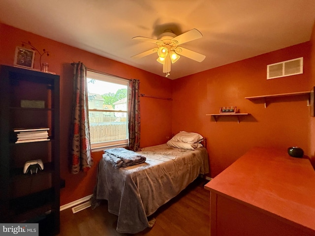 bedroom with dark wood-style floors, a ceiling fan, and baseboards