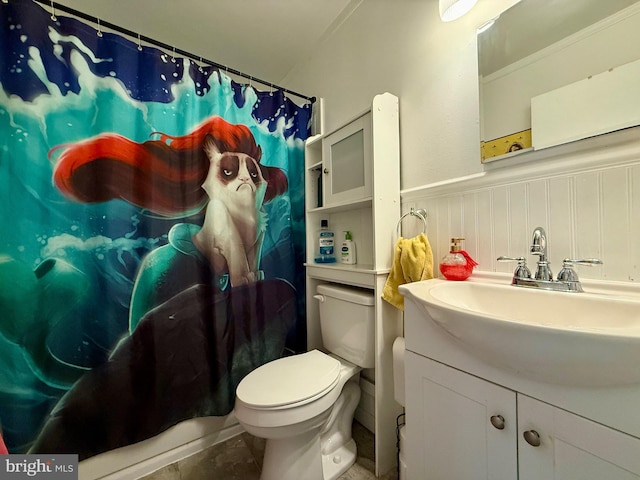 bathroom featuring wainscoting, toilet, vanity, a shower with curtain, and tile patterned flooring