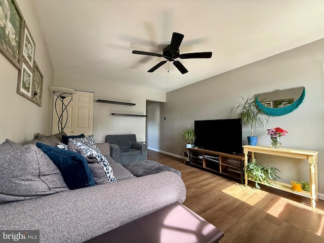 living room with wood finished floors, a ceiling fan, and baseboards