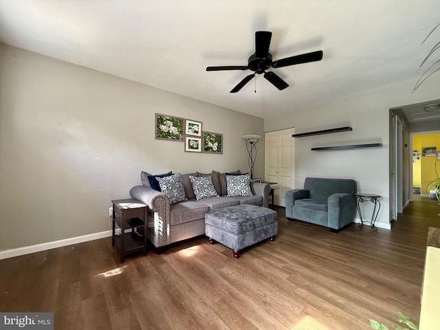 living area featuring wood finished floors, baseboards, and a ceiling fan