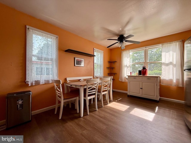 dining room featuring baseboards, dark wood-type flooring, and a ceiling fan
