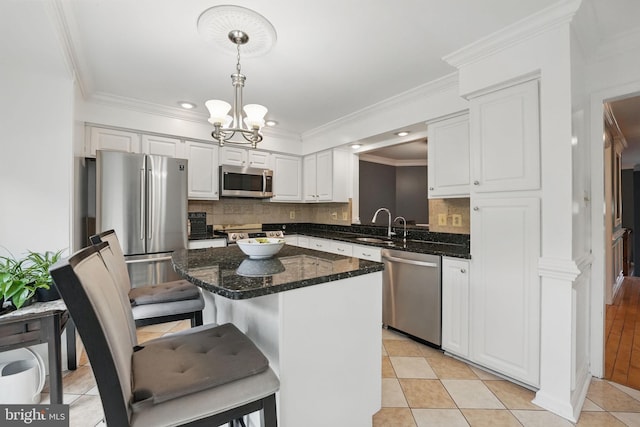 6410 Brass Button Ct, Centreville, VA 20121 - kitchen with appliances with stainless steel finishes, white cabinets, a chandelier, decorative backsplash, and a kitchen island