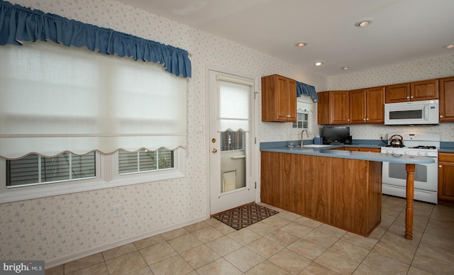 125 Wyndham Way, Harrisburg, PA 17109 - kitchen with white appliances, wallpapered walls, a sink, brown cabinetry, and a peninsula