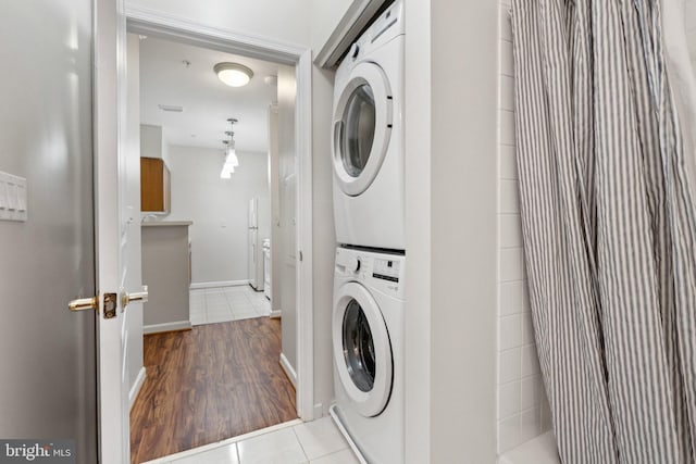 2204 Westcourt Ln Unit 122, Herndon, VA 20170 - washroom with estacked washer and dryer, tile patterned flooring, and baseboards