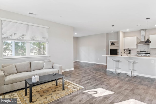 living room with wood finished floors, recessed lighting, and baseboards