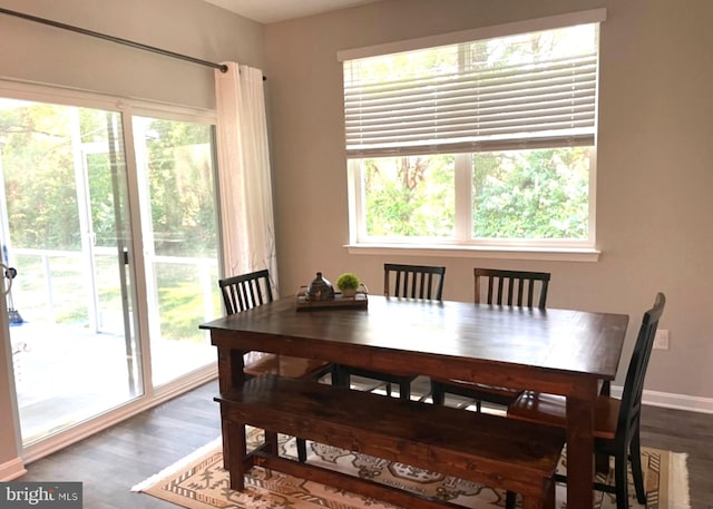 dining space with healthy amount of natural light, dark wood-style floors, and baseboards