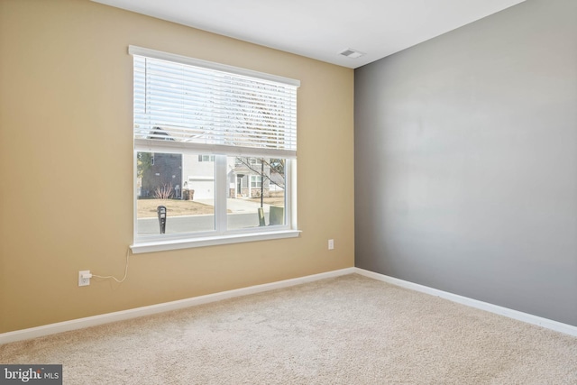 carpeted spare room featuring baseboards