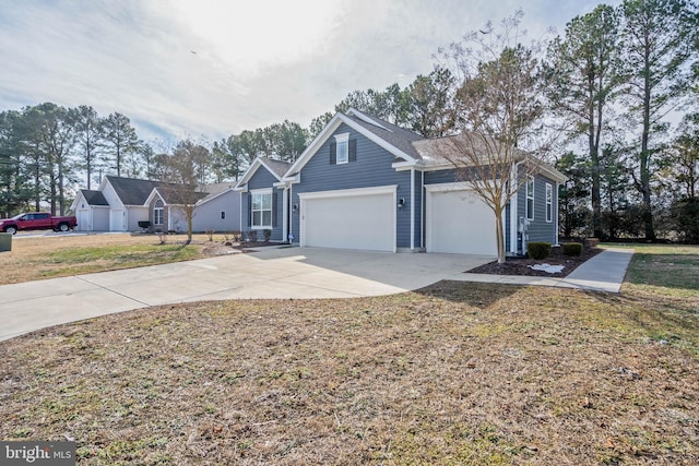 view of front of home featuring concrete driveway, an attached garage, and a front yard