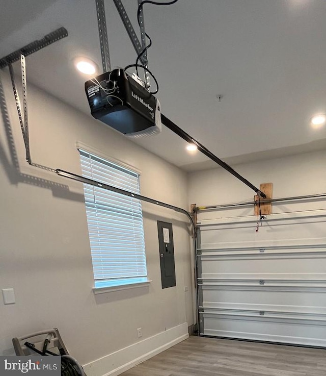 garage with electric panel, baseboards, a garage door opener, and recessed lighting