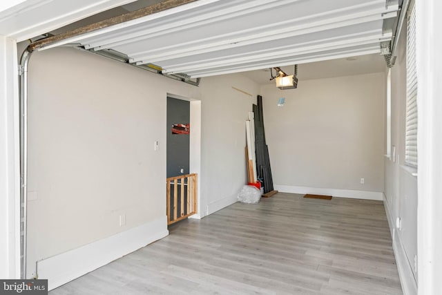 garage featuring a garage door opener and baseboards