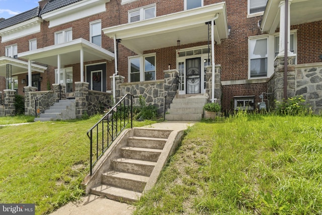 1609 E 33rd St, Baltimore, MD 21218 - view of front of property featuring a porch, brick siding, and a front yard