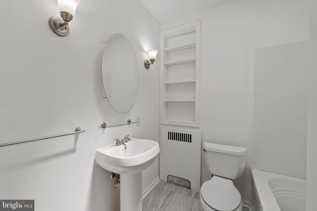 1609 E 33rd St, Baltimore, MD 21218 - bathroom featuring radiator, built in features, a bath, toilet, and marble look tiles