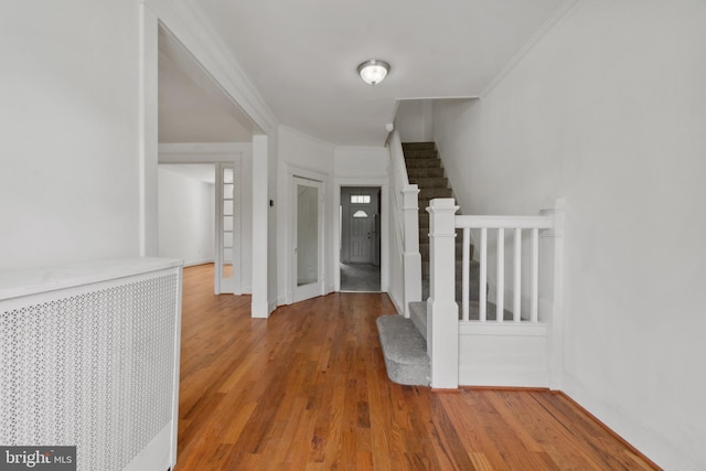 1609 E 33rd St, Baltimore, MD 21218 - hallway with wood finished floors, crown molding, stairway, and baseboards