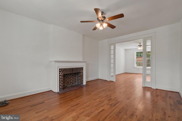 1609 E 33rd St, Baltimore, MD 21218 - unfurnished living room with a ceiling fan, wood finished floors, a fireplace with flush hearth, and baseboards