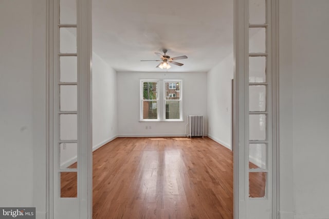 1609 E 33rd St, Baltimore, MD 21218 - spare room with radiator heating unit, light wood-type flooring, ceiling fan, and baseboards
