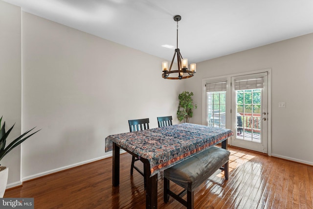dining room featuring a chandelier, hardwood / wood-style floors, and baseboards