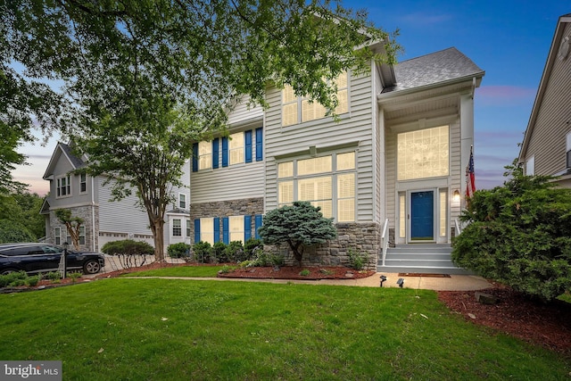 view of front of property with stone siding, a lawn, entry steps, and a shingled roof