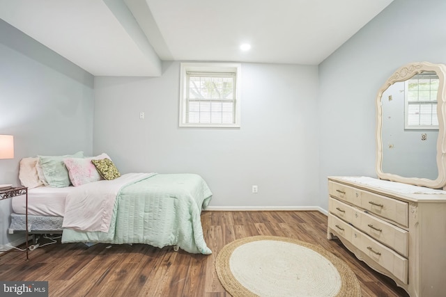 bedroom featuring wood finished floors, baseboards, and multiple windows