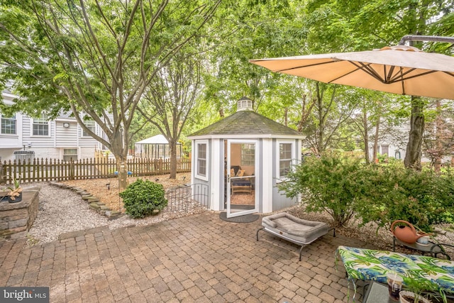 view of patio / terrace with fence and an outdoor structure