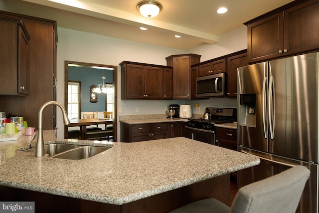 12 N Parsons Dr, Mill Hall, PA 17751 - kitchen featuring appliances with stainless steel finishes, a sink, a breakfast bar, dark brown cabinetry, and light stone counters