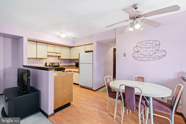223 Foxwood Ln, Marlton, NJ 08053 - kitchen with freestanding refrigerator, stainless steel range with gas cooktop, a peninsula, under cabinet range hood, and light wood-style floors