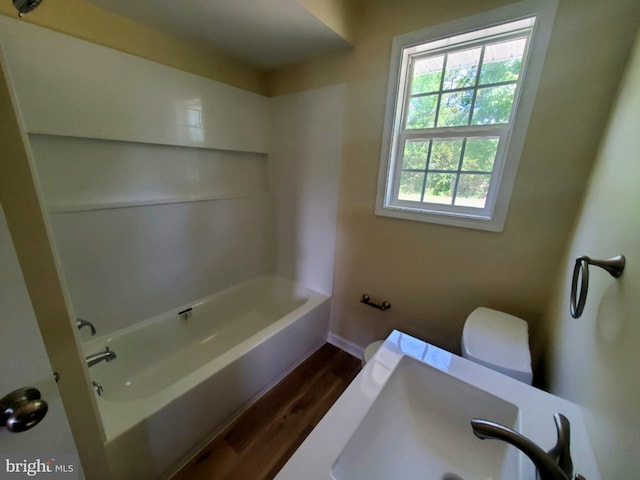 4302 Messick Rd, Rhodesdale, MD 21659 - bathroom with wood finished floors, toilet, a sink, baseboards, and shower / bathtub combination
