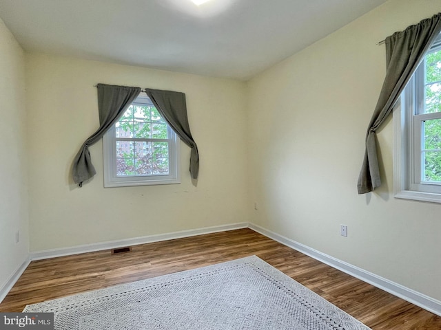7972 Lakecrest Dr, Greenbelt, MD 20770 - empty room with plenty of natural light, wood finished floors, and baseboards