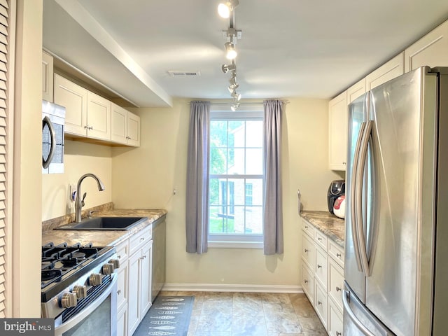 7972 Lakecrest Dr, Greenbelt, MD 20770 - kitchen with appliances with stainless steel finishes, a sink, white cabinetry, baseboards, and light stone counters