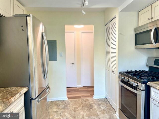 7972 Lakecrest Dr, Greenbelt, MD 20770 - kitchen with stainless steel appliances, rail lighting, light stone counters, and baseboards