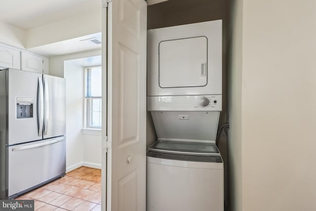 810 N Fayette St, Alexandria, VA 22314 - laundry area with stacked washing machine and dryer, light tile patterned floors, and baseboards