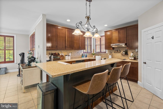 670 Good Shepherd Way, Owings, MD 20736 - kitchen featuring under cabinet range hood, light tile patterned floors, tasteful backsplash, a kitchen breakfast bar, and recessed lighting