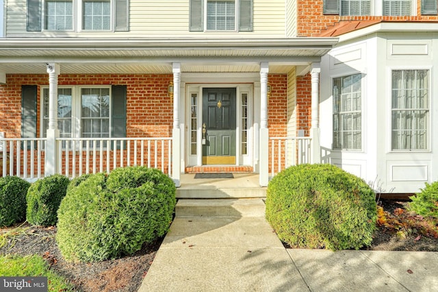property entrance featuring brick siding and covered porch