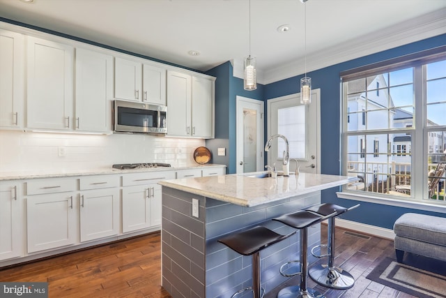 801 Skippers Ln, Annapolis, MD 21401 - kitchen featuring stainless steel appliances, dark wood finished floors, white cabinets, a breakfast bar, and decorative light fixtures