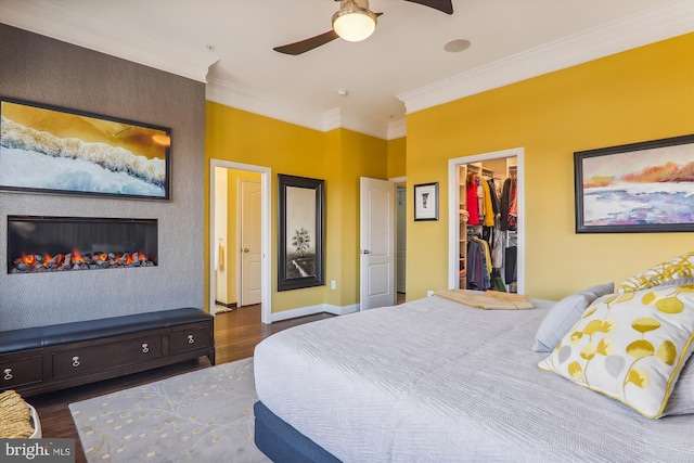 801 Skippers Ln, Annapolis, MD 21401 - bedroom with wood finished floors, a spacious closet, ornamental molding, a fireplace, and baseboards
