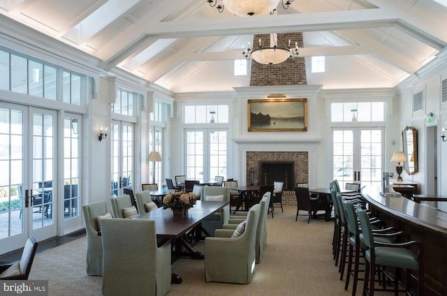 carpeted dining space with french doors, high vaulted ceiling, healthy amount of natural light, and beamed ceiling