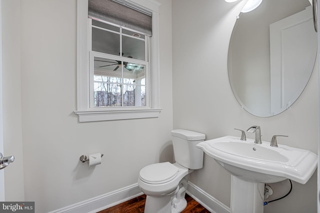 bathroom featuring wood finished floors, baseboards, and toilet
