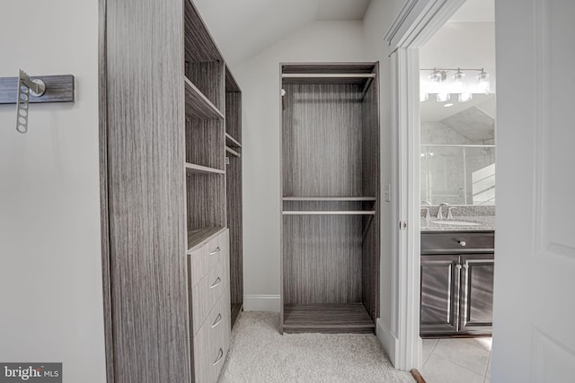 walk in closet with a sink and lofted ceiling