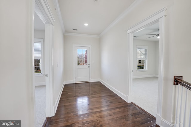 doorway to outside featuring plenty of natural light, dark wood-style floors, ornamental molding, a ceiling fan, and baseboards