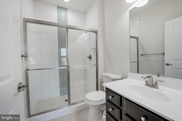 full bath with toilet, a stall shower, vanity, and tile patterned floors