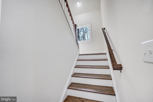 stairs featuring wood finished floors and baseboards
