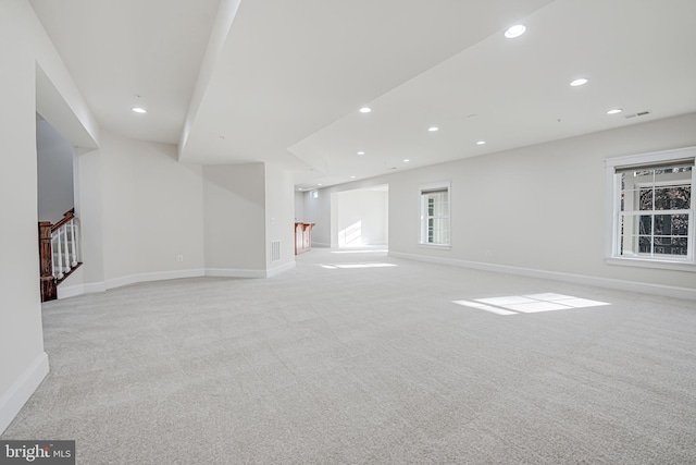 carpeted empty room with stairs, baseboards, recessed lighting, and bar area