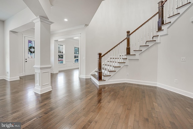 entrance foyer with ornate columns, dark wood-style floors, stairway, baseboards, and recessed lighting
