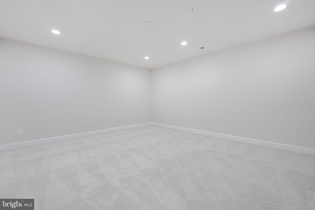 spare room featuring recessed lighting, baseboards, and light carpet