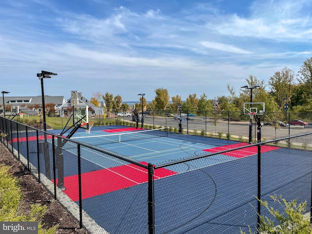 view of tennis court with community basketball court and fence