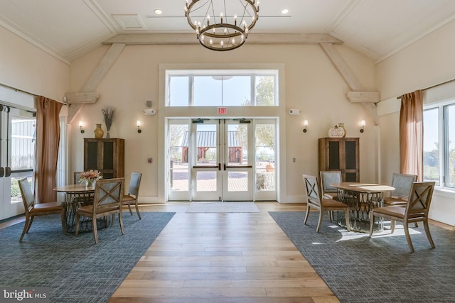 dining room featuring high vaulted ceiling, a chandelier, wood finished floors, french doors, and ornamental molding