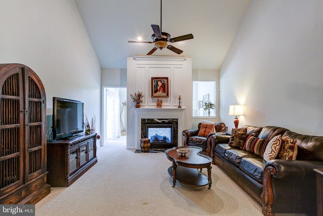 carpeted living room with ceiling fan, a premium fireplace, and high vaulted ceiling